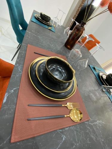 a table with plates and utensils on a table at L'heure de la détente Spa privatif in Beauraing