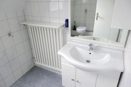 a white bathroom with a sink and a toilet at FerieninNordhorn in Nordhorn