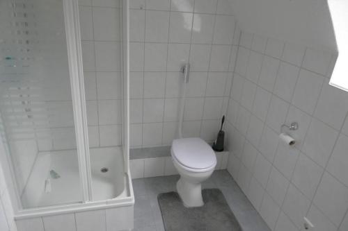 a white bathroom with a toilet and a shower at FerieninNordhorn in Nordhorn