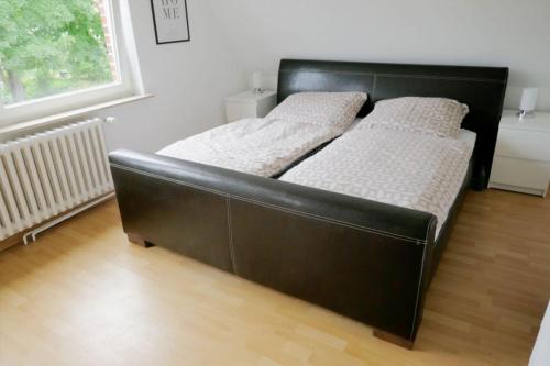 1 cama negra con 2 almohadas blancas en una habitación en FerieninNordhorn en Nordhorn