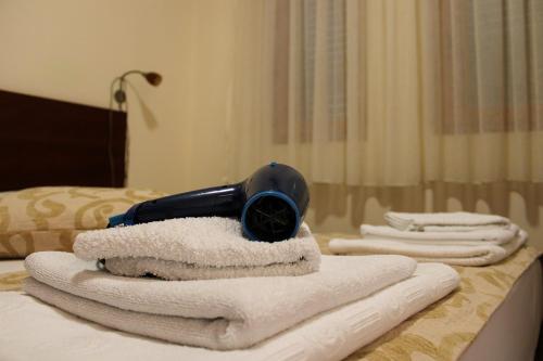 a blow dryer sitting on a pile of towels on a bed at Apartments MUN Petrovac in Petrovac na Moru