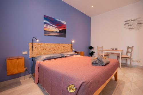 a bedroom with a king sized bed with purple walls at Pesce Palla Affittacamere in Finale Ligure