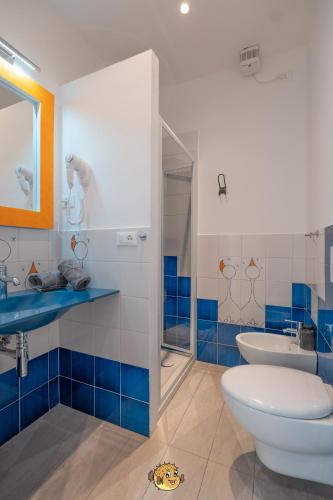a blue and white bathroom with a toilet and a sink at Pesce Palla Affittacamere in Finale Ligure