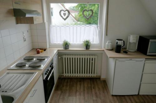 uma cozinha com um fogão e uma janela com corações em FerieninNordhorn em Nordhorn