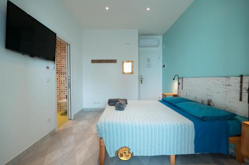a bedroom with a bed and a flat screen tv at Pesce Palla Affittacamere in Finale Ligure