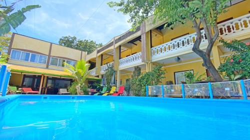 a swimming pool in front of a house at Hôtel Restaurant Coco Lodge Majunga in Mahajanga