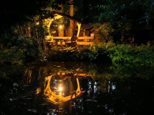 a boat in the water in front of a house at night at Hasenstall in Rehburg-Loccum