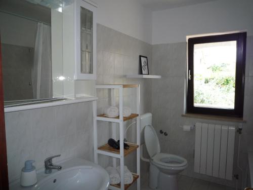 baño con lavabo y aseo y ventana en Tina, en Poreč