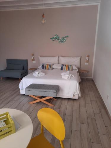 a bedroom with a bed and a yellow chair at Casa di Magda in Castellammare del Golfo