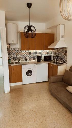una cocina con lavadora y un sofá en una habitación en Casa el Anden 11, en El Bosque