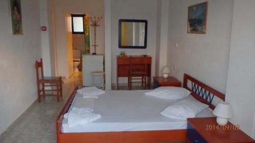 1 dormitorio con 1 cama, mesa y sillas en Mylos Garden, en Livadi
