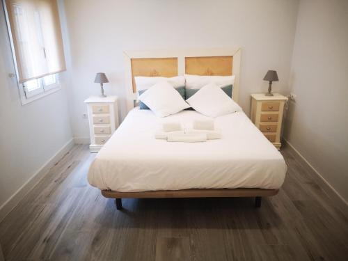 a bedroom with a large white bed with two night stands at Beautiful Apartment in the heart of seville in Seville