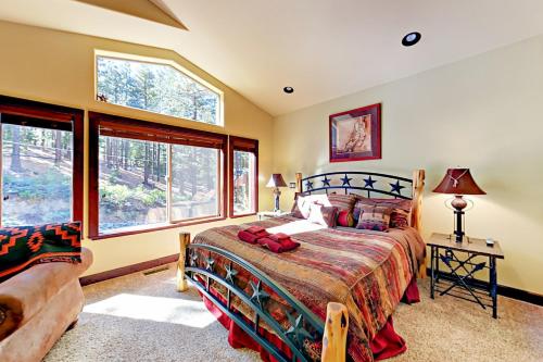 ein Schlafzimmer mit einem Bett und zwei Fenstern in der Unterkunft High Meadow Escape in South Lake Tahoe