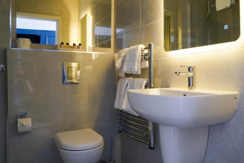 a white bathroom with a sink and a toilet at Alcock & Brown Hotel in Clifden