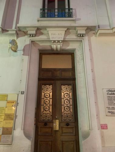 a wooden door in a building with a balcony at Les Terrasses, charme et authenticité en Hyper Centre de TOULON, Idéal pour un séjour romantique ou une escapade urbaine in Toulon