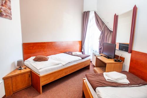 a bedroom with two beds and a desk with a computer at Penzión Tücsök in Šamorín