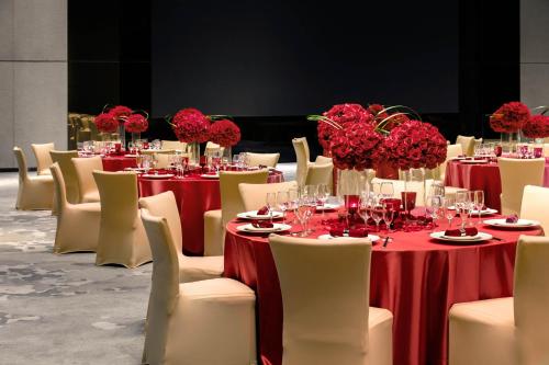a dining room with red tables and white chairs at Niccolo Changsha in Changsha