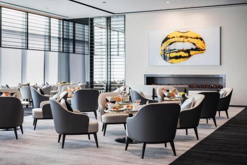 a restaurant with tables and chairs and a fireplace at Niccolo Changsha in Changsha