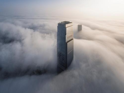 a skyscraper in the fog with a building in the middle at Niccolo Changsha in Changsha