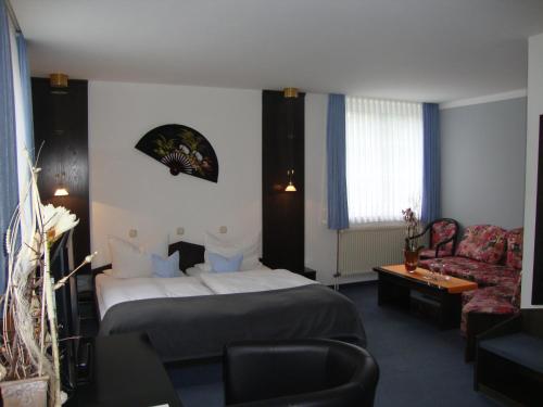 PockauにあるHotel Bergschlößchenのベッドとソファ付きのホテルルーム