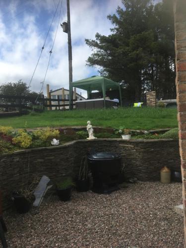 a brick wall with a fountain in a garden at Crockgarve B and B in Galbally