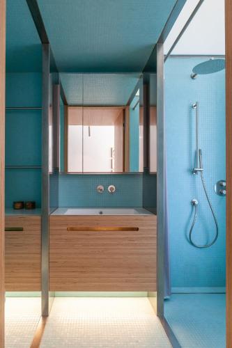 a blue bathroom with a shower and a mirror at Wyspa 12 in Poznań