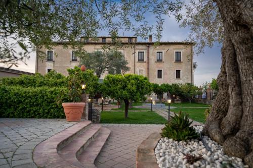 a large building with trees and a brick walkway at Tenuta Ciminata Greco in Rossano