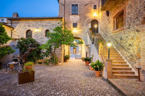 an alley in an old building with stairs and potted plants at Tenuta Ciminata Greco in Rossano