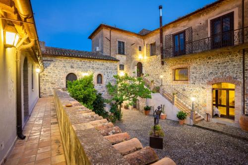 a courtyard of an old stone building with a pathway at Tenuta Ciminata Greco in Rossano