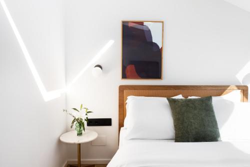 a bedroom with a white bed with a green pillow at Noa Hotel in Thessaloniki