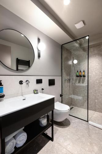 a bathroom with a sink and a toilet and a mirror at Noa Hotel in Thessaloniki