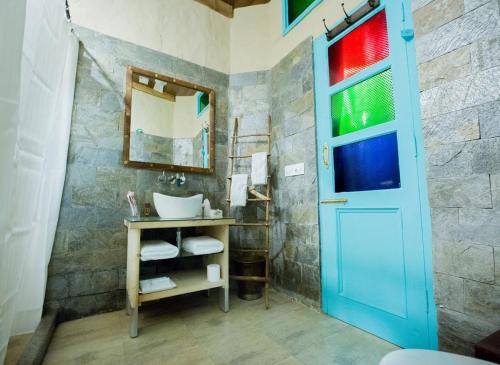 a bathroom with a sink and a blue door at WelcomHeritage Ranjitvilas in Amritsar