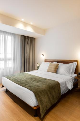 a bedroom with a large bed with white sheets and pillows at Noa Hotel in Thessaloniki