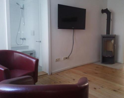 ein Wohnzimmer mit einem Stuhl und einem TV an der Wand in der Unterkunft Apartment in der Altstadt in Ueckermünde