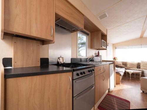 a kitchen with wooden cabinets and a stove top oven at Crockgarve B and B in Galbally