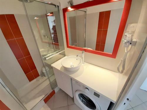 une salle de bain avec toilettes, lavabo et miroir dans l'établissement Studio Village Naturiste Carino, au Cap d'Agde