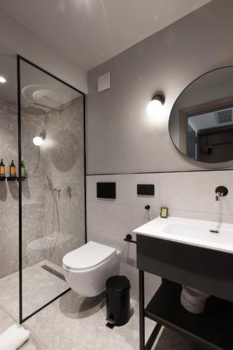 a bathroom with a toilet and a shower and a sink at Noa Hotel in Thessaloniki