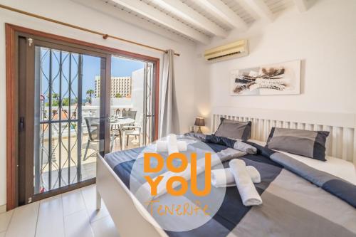 a bedroom with a bed with a do you sign on it at Apartment Paraiso Royal in Arona