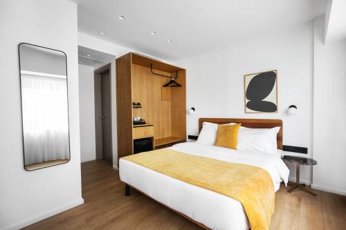 a bedroom with a large bed and a mirror at Noa Hotel in Thessaloniki