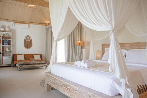a bedroom with a large bed with a canopy at Hot Stone Club Ubud in Ubud
