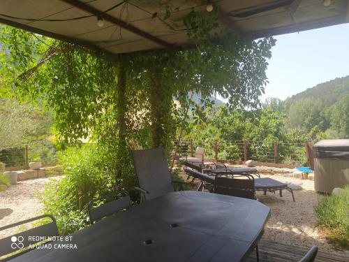 a group of tables and chairs under a tree at Le Paillier d'Etienne. in La Cresse