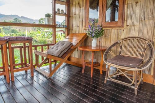 a wooden room with a table and chairs on a balcony at The Nest House in Pai