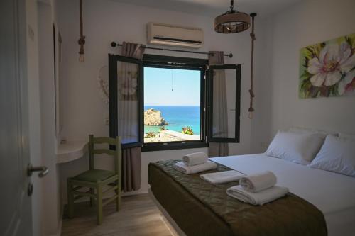 a bedroom with a window with a view of the beach at Blue Bliss in Ambrami