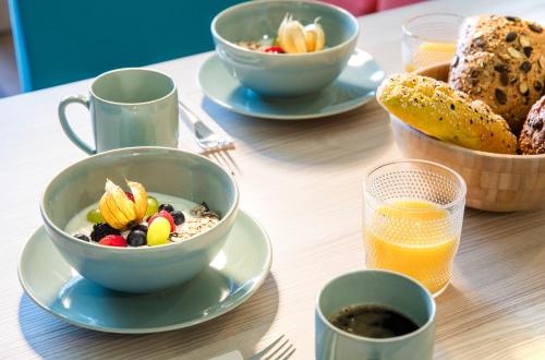 a table with bowls of breakfast food and a bowl of bread at Hi5-Hotel Seiersberg in Windorf