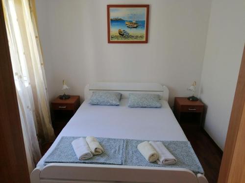 a bedroom with a bed with two towels on it at Apartmani Ljumović Budva in Budva