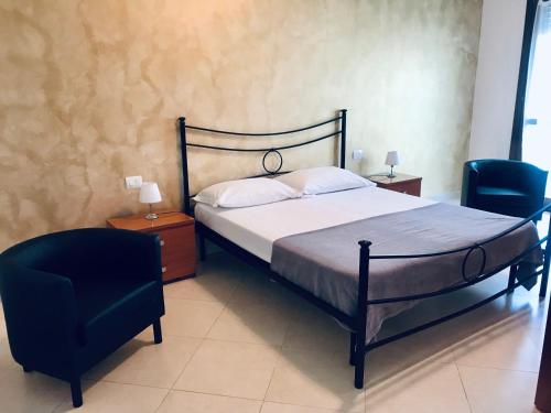 una camera con un letto e due sedie di Appartamenti Angelica 2 a Pisa