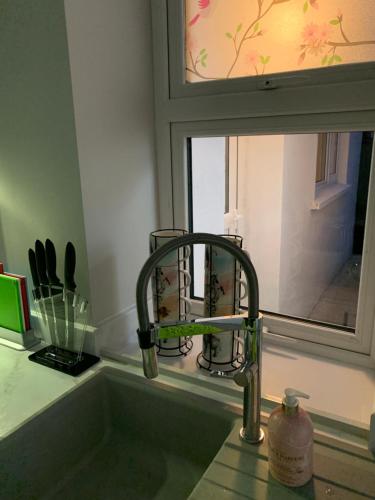 a kitchen sink with a faucet and a window at Seaview Aurora House - Central Luxury Apartment in Warrenpoint