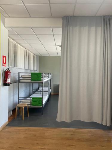 a room with bunk beds and a curtain at Albergue Rem in O Pino 