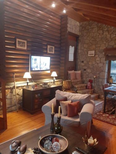 a living room with a couch and a tv at Mouses Chalet Lydia Επτάλοφος Παρνασσού in Eptalofos