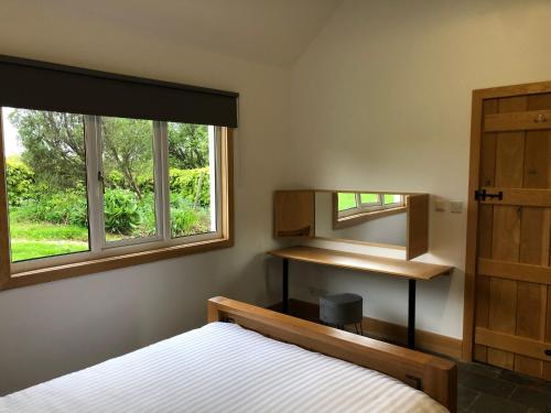 a bedroom with a bed and a mirror and a window at The Cottage, near Glasgow Milngavie in Milngavie